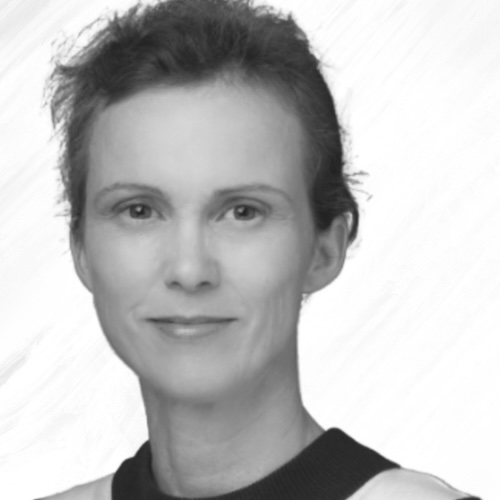 Black and white portrait of a woman with short, wavy hair, wearing a dark-collared top, looking at the camera with a neutral expression against a light background.